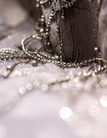 A macro view reveals the exquisite craftsmanship of hand-sewn silver beads on delicate lace.の素材