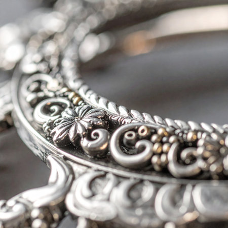 A macro photograph captures the exquisite, handcrafted details of an ornate piece of vintage silver.の素材