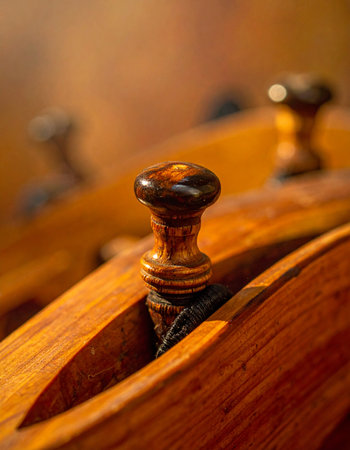 A detailed macro shot captures the elegant craftsmanship of a wooden tuning peg on a classic acoustic guitar.の素材