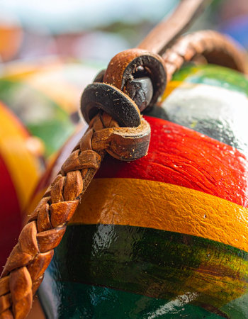 A macro view captures the vibrant, hand-painted stripes of a traditional maraca.の素材