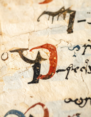 A close-up reveals the intricate detail of an illuminated capital letter on a page from a historic manuscript.の素材