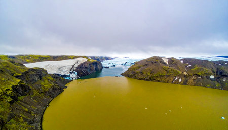 An expansive aerial perspective captures the dramatic meeting of a vast Icelandic glacier and its meltwater lake.の素材