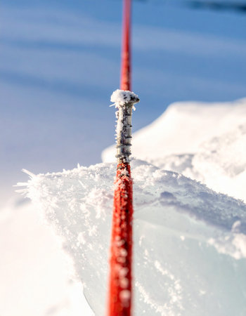 A close-up macro shot captures the critical connection point in ice climbing.の素材
