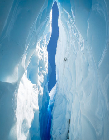 A breathtaking view from within a deep glacial crevasse, where ancient ice glows with an ethereal blue light.の素材