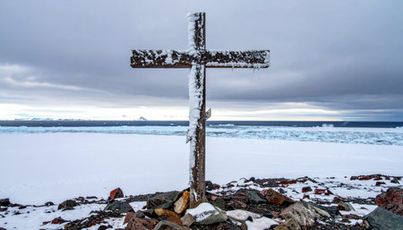 A weathered wooden cross stands as a solemn memorial against the vast, frozen expanse of Antarctica.の素材
