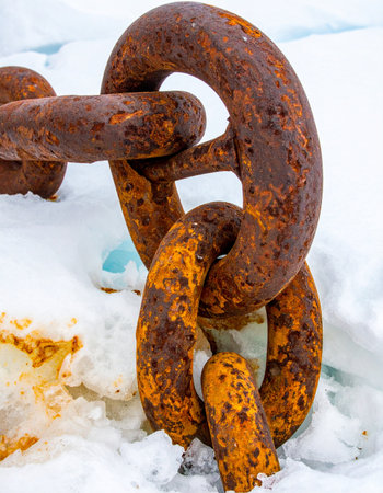 Once a vital link in a powerful machine, this heavy, corroded chain now rests abandoned in the ice.の素材