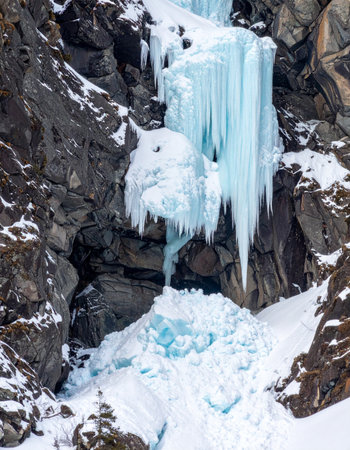 A massive waterfall is captured mid-flow, frozen solid by the deep winter cold.の素材