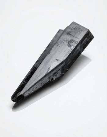 A single, powerful shard of raw metallic ore rests against a stark white background.の素材