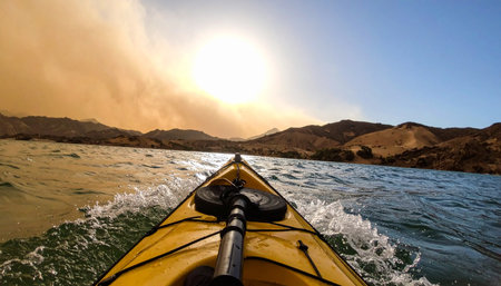 A first-person perspective from a yellow kayak cutting through choppy water.の素材