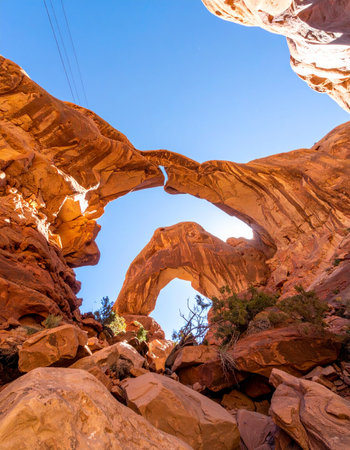 A stunning low-angle view looking up through the magnificent Double Arch in Utah's Arches National Park.の素材