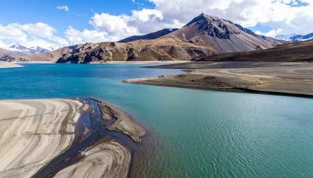A breathtaking panoramic view of a vibrant turquoise lake nestled within a vast, arid mountain range.の素材