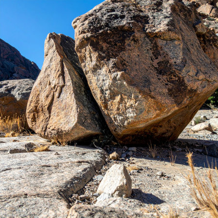 Two colossal boulders, weathered by millennia, rest in a delicate balance on a solid rock foundation.の素材