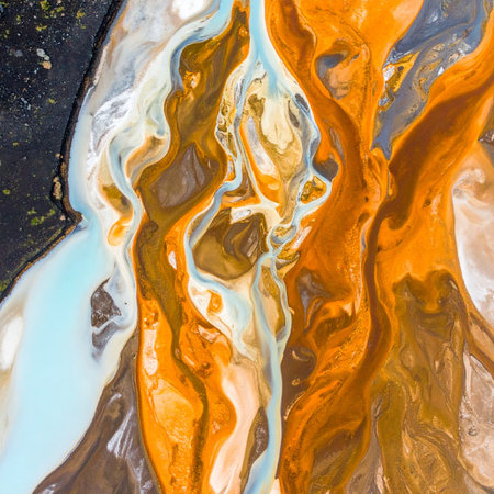 A dynamic and chaotic dance of colors unfolds as vibrant orange, earthy brown, and cool blue liquids swirl and mix together.の素材