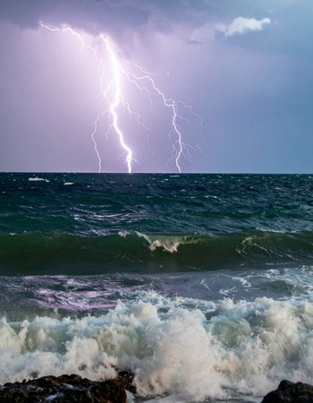 Witness the raw, untamed power of nature as multiple forks of brilliant lightning illuminate a dark, stormy sky. Below, the ocean churns in a turbulent display, its waves crashing with immense energy, capturing a moment of awe-inspiring natural fury.の素材