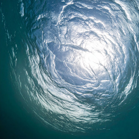 From the quiet depths, a view upwards reveals the suns brilliant light dancing and swirling on the waters surface. This abstract perspective evokes a sense of peace, hope, and the serene beauty of the natural world, offering a moment of tranquil escape.の素材