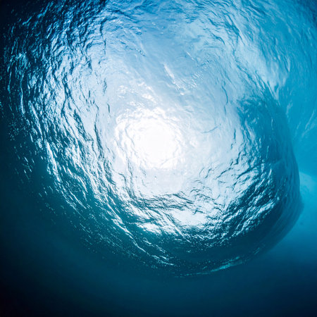 From the quiet depths, a view upwards towards the sunlit surface. The rippling water creates a mesmerizing, abstract pattern of light and shadow, evoking a sense of peace, hope, and serene solitude. A perfect natural background for concepts of tranquility and discovery.の素材