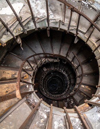 Looking down into the abyss of a forgotten industrial building, this decaying spiral staircase twists into darkness. Each rusted step tells a story of abandonment and the relentless passage of time, creating a powerful visual of decay and mystery.の素材