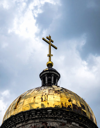 A magnificent golden dome, crowned with an Orthodox cross, reaches towards a dramatic and cloudy sky. The gilded surface reflects the heavens, creating a powerful symbol of faith, history, and spiritual aspiration against the vastness of the atmosphere.の素材