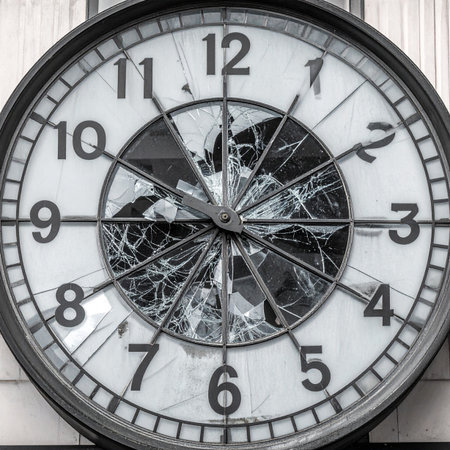 A dramatic close-up of a vintage clock with a shattered glass face. The broken dial symbolizes a critical moment, the end of an era, or the destructive pressure of a deadline. Its a powerful metaphor for failure, crisis, and the irreversible passage of time.の素材