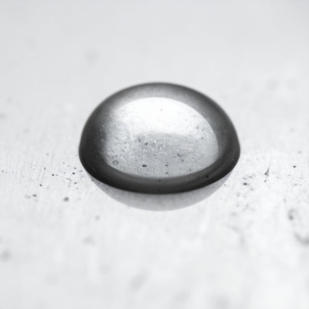 A single, perfect sphere of liquid metal rests on a clean white surface. This macro photograph captures the simple elegance and futuristic feel of a solitary element, symbolizing concepts of purity, precision, and the beginning of a new idea.の素材