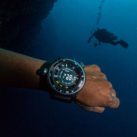 From a first-person perspective, a scuba diver checks their advanced digital dive computer deep beneath the oceans surface. The illuminated display provides critical data, ensuring safety and precision during an underwater exploration adventure in the tranquil blue.の素材