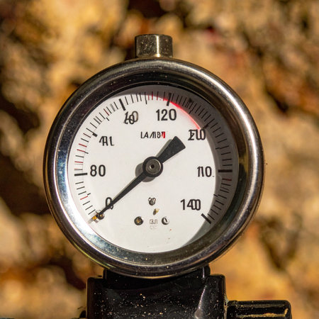 A close-up view captures the tension as an industrial pressure gauges needle climbs towards the maximum limit. This image symbolizes performance under stress, critical monitoring, and the fine line between optimal operation and system failure.の素材