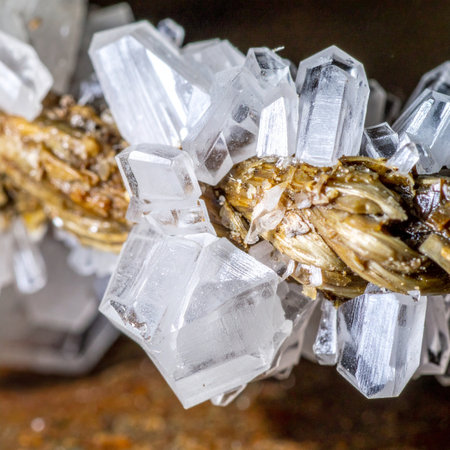 A stunning macro photograph captures the intricate beauty of a natural crystal formation. Clear, geometric points emerge from a golden, metallic base, showcasing the raw, untouched elegance of geological wonders. This image evokes a sense of discovery, purity, and the precious treasures hidden within the earth.の素材