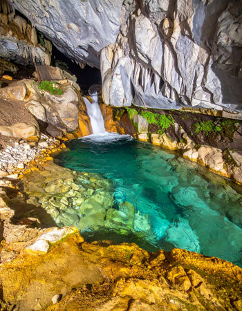 Deep beneath the earths surface, a hidden waterfall cascades into a crystal-clear turquoise pool. This serene grotto, illuminated to reveal ancient rock formations and stalactites, offers a moment of tranquil discovery and natural wonder, a secret oasis waiting to be explored.の素材