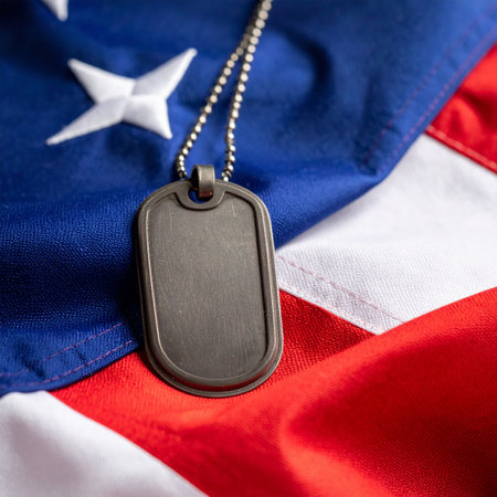 A single, blank military dog tag rests upon the red, white, and blue of the American flag. This poignant image serves as a powerful symbol of service, sacrifice, and the solemn honor bestowed upon those who have served their country, evoking remembrance for fallen heroes and respect for veterans.の素材