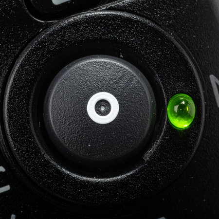 A macro view captures the moment of activation. A single green LED glows brightly, signaling that the system is online, active, and ready to perform.の素材