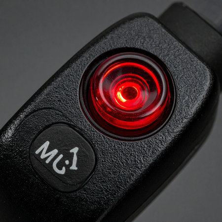 A close-up of a modern electronic device shows a glowing red indicator light, suggesting power, recording, or an active AI presence.の素材