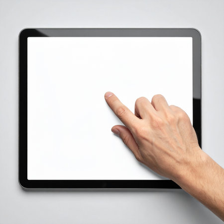A user's hand reaches out to interact with a modern digital tablet, the blank white screen a canvas for new ideas, applications, and connections.の素材