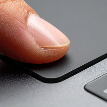 In a moment of focused concentration, a single finger makes contact with a sleek, modern keyboard.の素材
