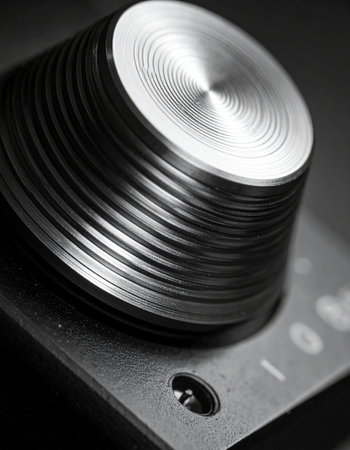 A detailed macro shot captures the intricate, circular texture of a brushed metal control knob.の素材