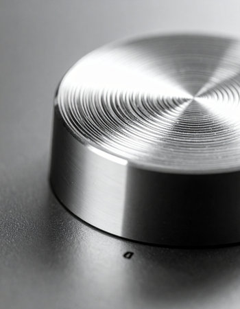 A macro view captures the intricate, circular texture of a brushed metal control knob.の素材