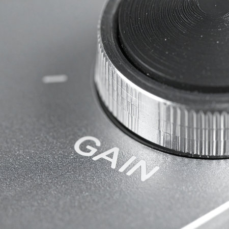 A detailed macro view captures the textured metal surface of a gain knob on professional audio equipment.の素材