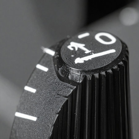 A macro, black and white photograph of a textured control knob on a piece of vintage audio equipment.の素材