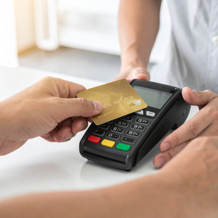 A customer completes a quick and secure purchase by tapping their gold credit card on a modern POS terminal.の素材