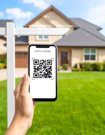 A prospective homebuyer uses their smartphone to scan a QR code on a real estate sign, instantly accessing details for an open house.の素材