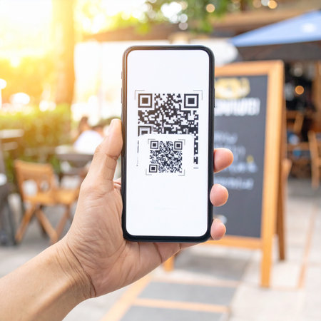 A person holds a smartphone to scan a QR code for a digital menu at a sunny outdoor restaurant patio.の素材