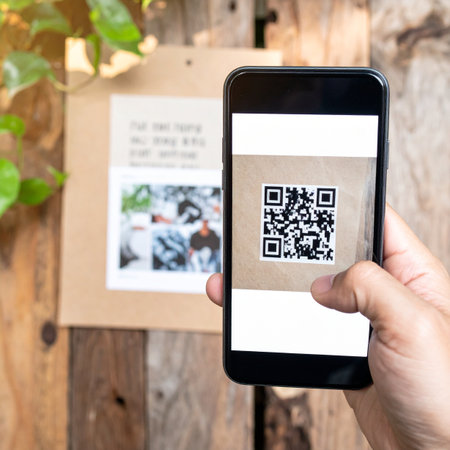 A person uses their smartphone to scan a QR code on a rustic wooden display, instantly accessing digital information or making a contactless payment.の素材