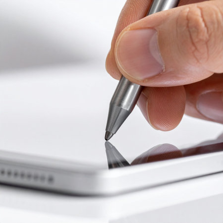 A close-up captures the moment of digital creation as a hand precisely guides a stylus across a tablet's sleek screen.の素材