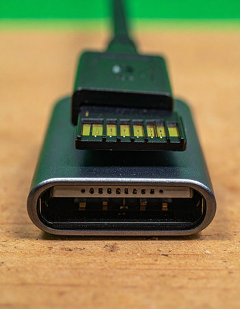 A macro view captures the precise moment of connection between a universal USB-C cable and a sleek metallic adapter.の素材