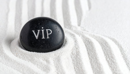 A smooth black stone engraved with 'VIP' rests on a plush, white striped towel, symbolizing exclusive access, premium service, and the ultimate luxury experience.の素材