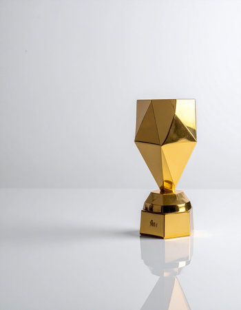 A gleaming, modern golden trophy stands proudly against a clean white background, its geometric facets reflecting light.の素材