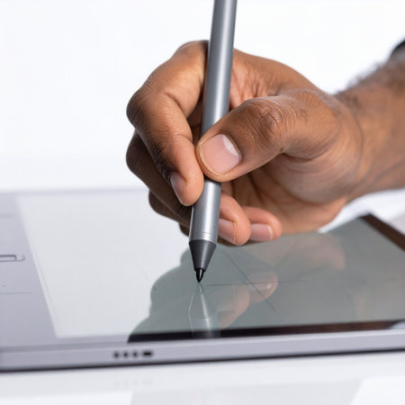 A close-up view captures the precise moment a designer's hand guides a stylus across a digital tablet.の素材