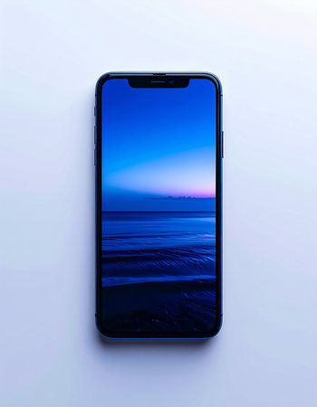 A modern smartphone rests on a clean white surface, its screen glowing with a tranquil ocean sunset.の素材