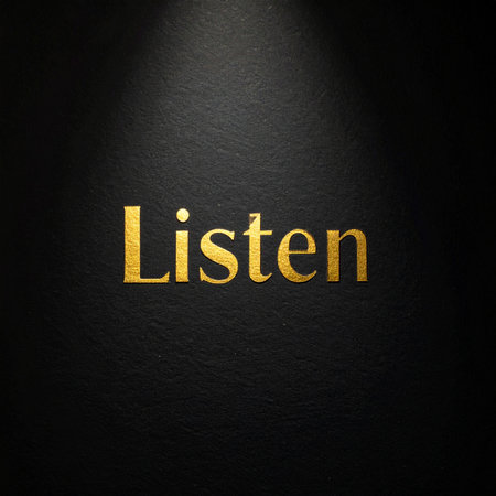 A single, powerful word, 'Listen,' rendered in elegant golden typography, is illuminated by a spotlight against a dark, textured background.の素材