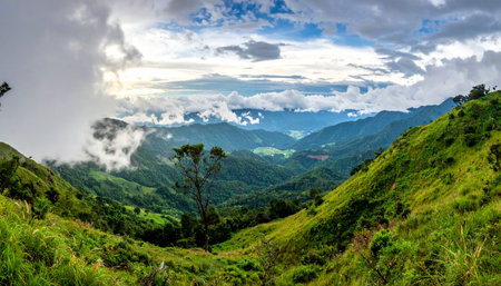From a high vantage point, the world unfolds into a breathtaking panorama of rolling green hills and distant mountain peaks.の素材