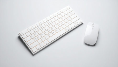 A clean, uncluttered desk setup featuring a sleek white wireless keyboard and mouse.の素材